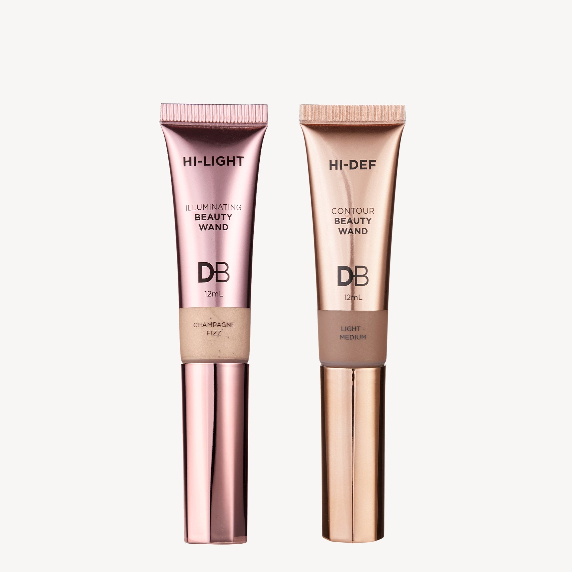 Two beauty wands on a light background: one pink, labelled "Illuminating," and one bronze, labelled "Contour." Luxury skincare packaging.