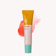 Lip balm tube with orange cap and pink base on a white background