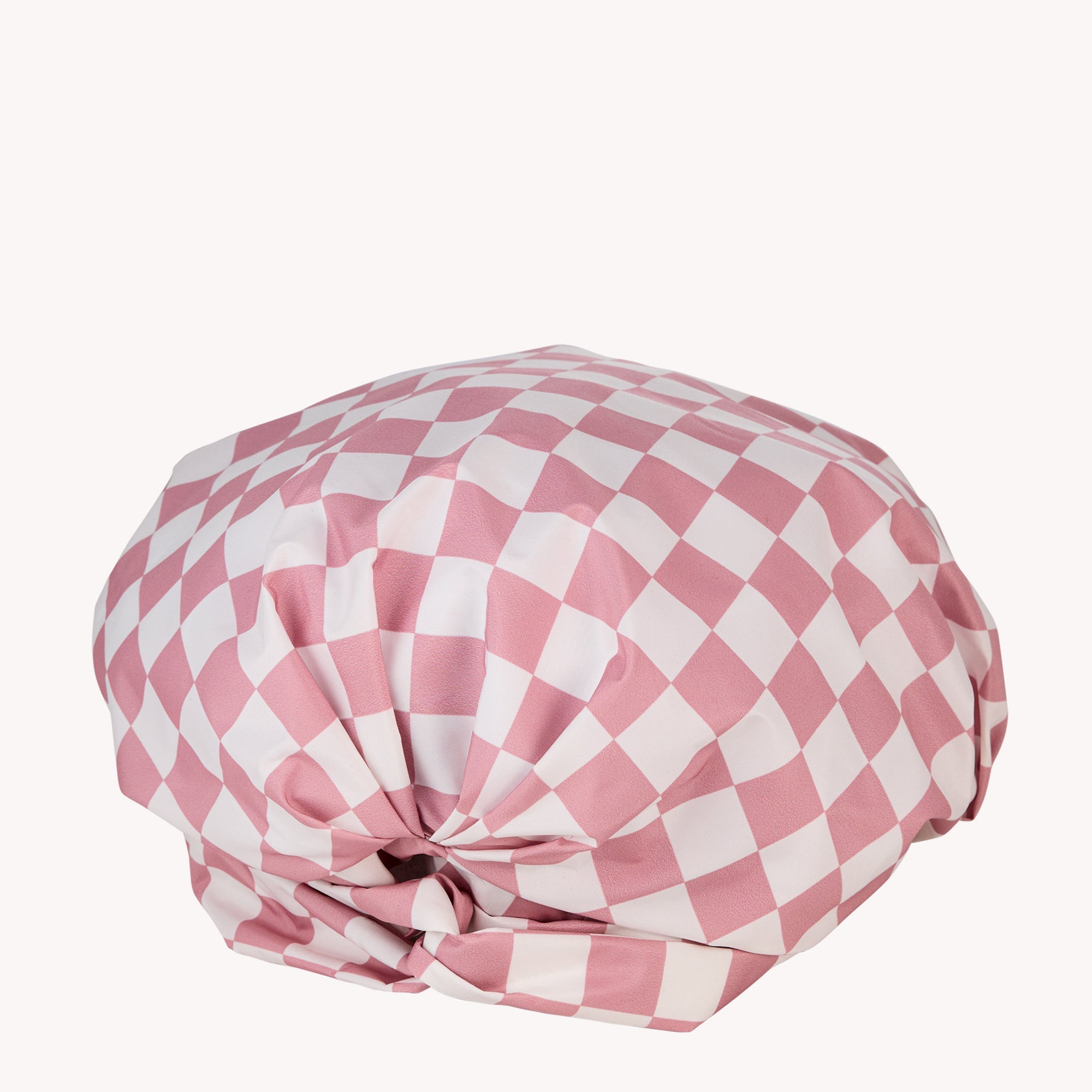 Pink and white chequered fabric bundle, resembling a wrapped gift, on a plain background, hinting at luxury jewellery presentation.