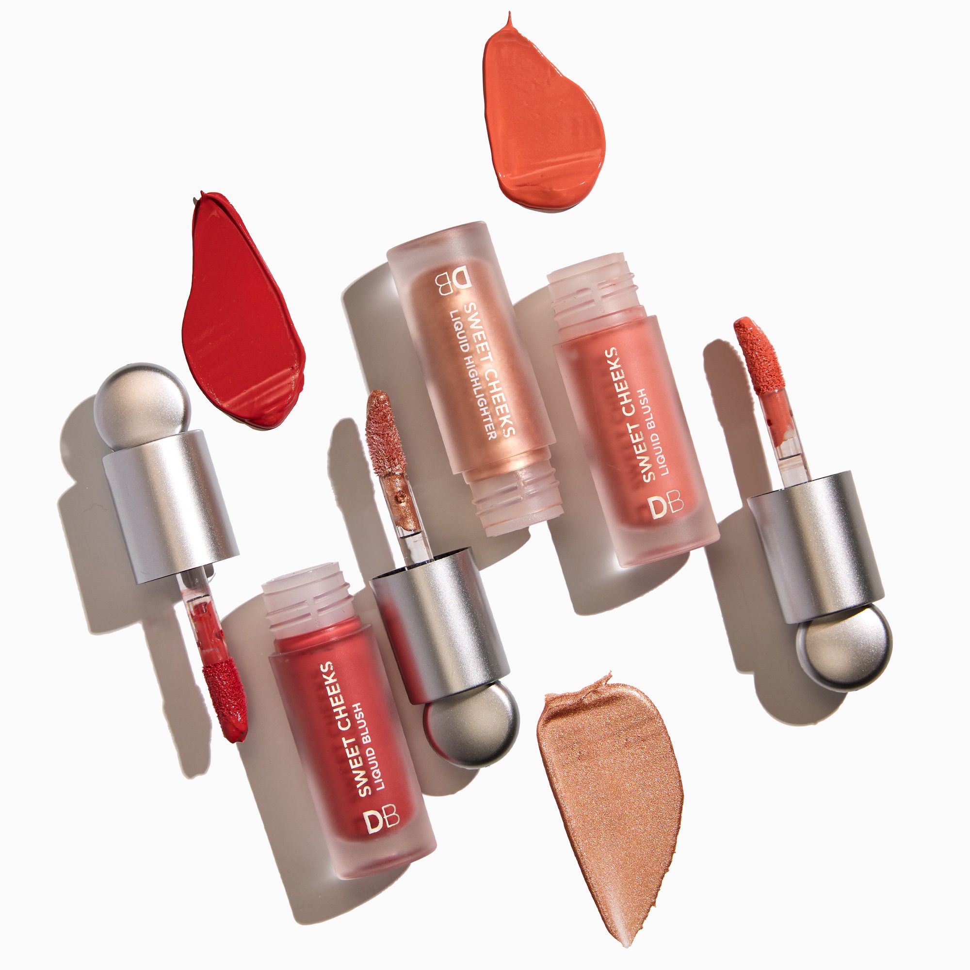 Set of lip glosses with applicators and color swatches on a white background