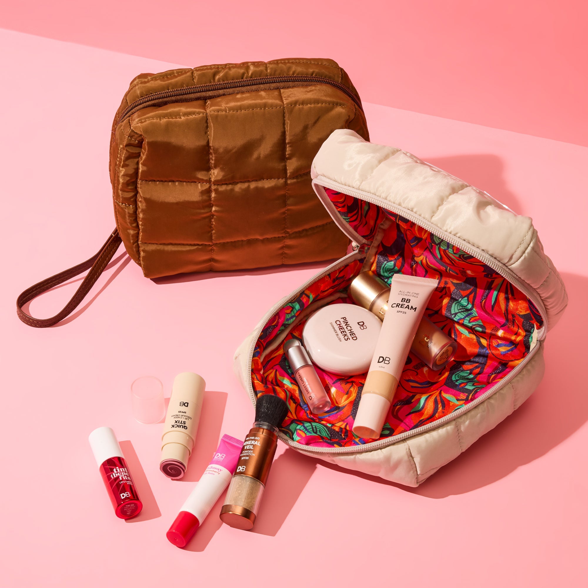 Makeup bag with colorful interior, makeup items on a pink background