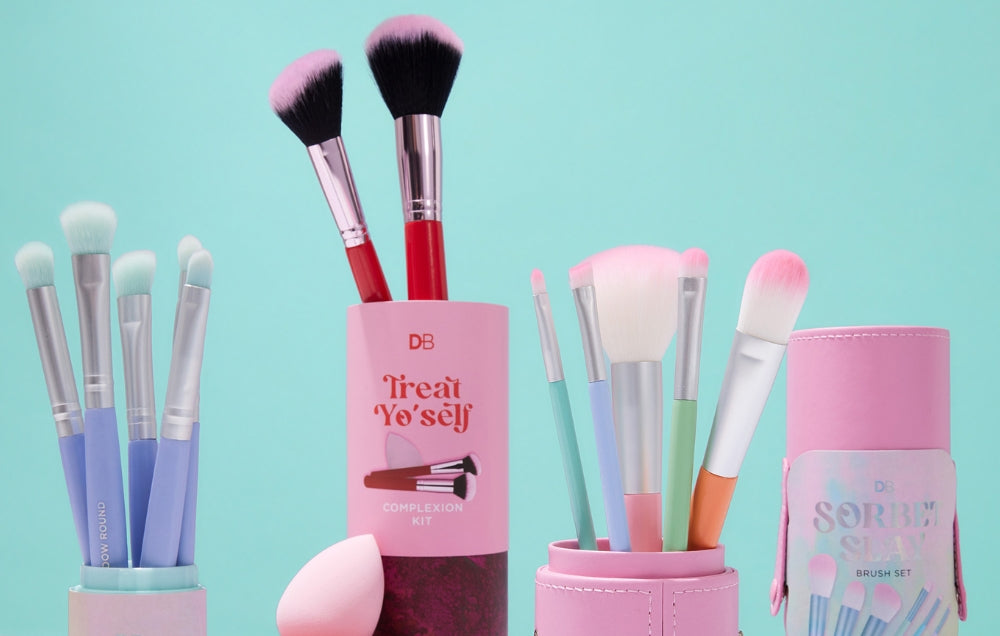 Assorted pastel makeup brush sets in chic holders against a turquoise background, featuring a "Treat Yo' Self" design.