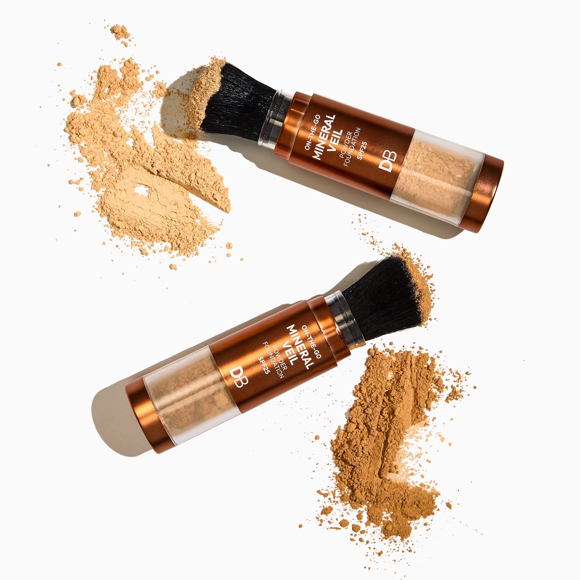 Two makeup products with brush applicators and scattered powder on a white background
