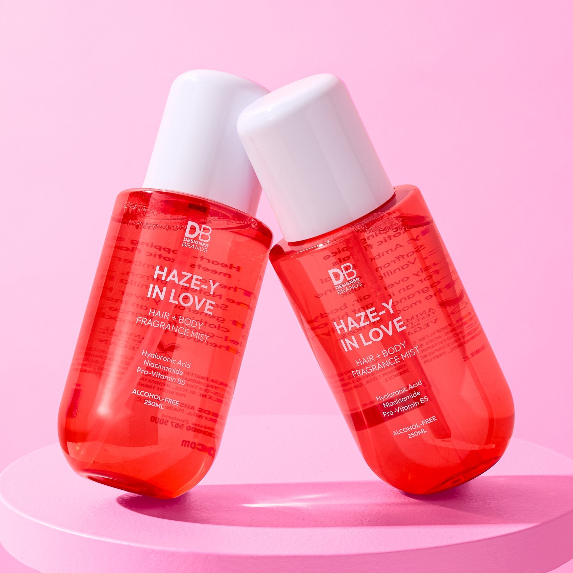 Two red bottles labeled 'Haze-y in Love' on a pink background