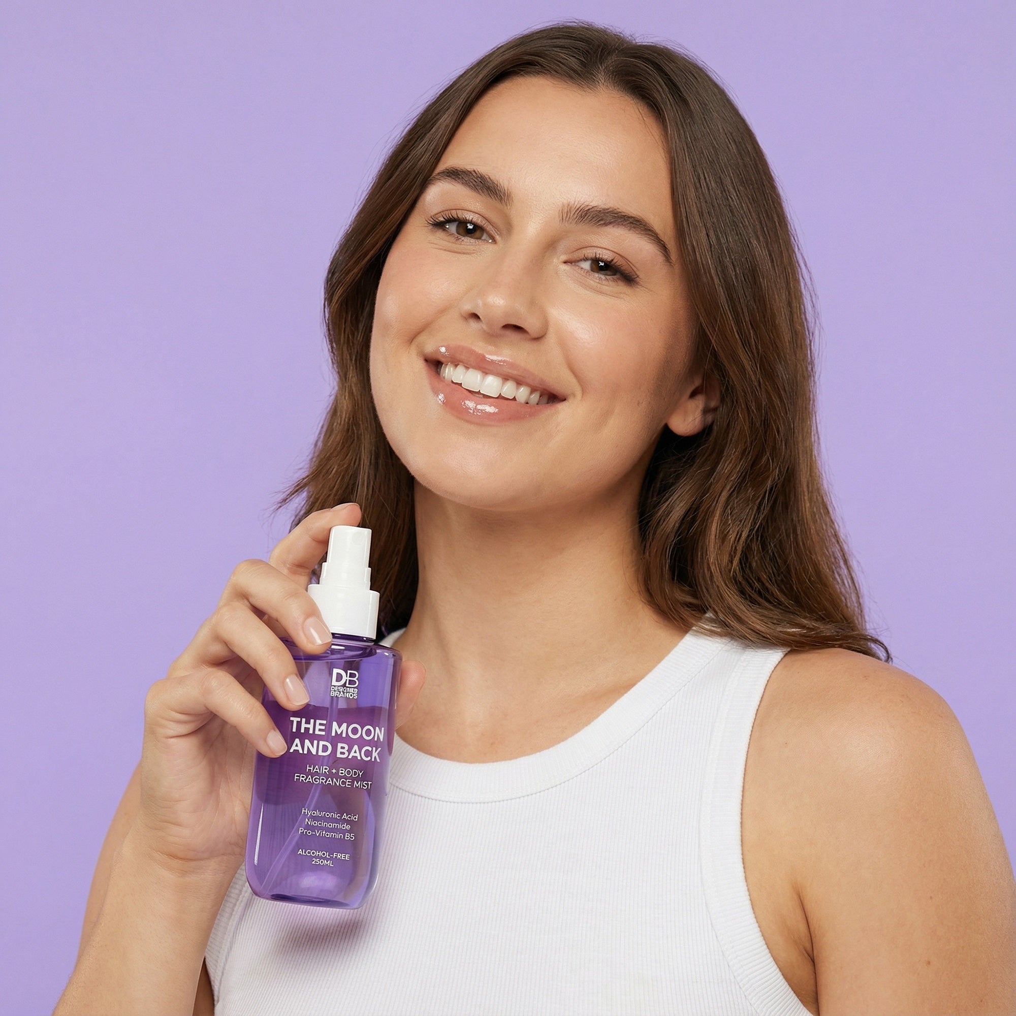 Woman holding a purple bottle with a white spray nozzle against a purple background